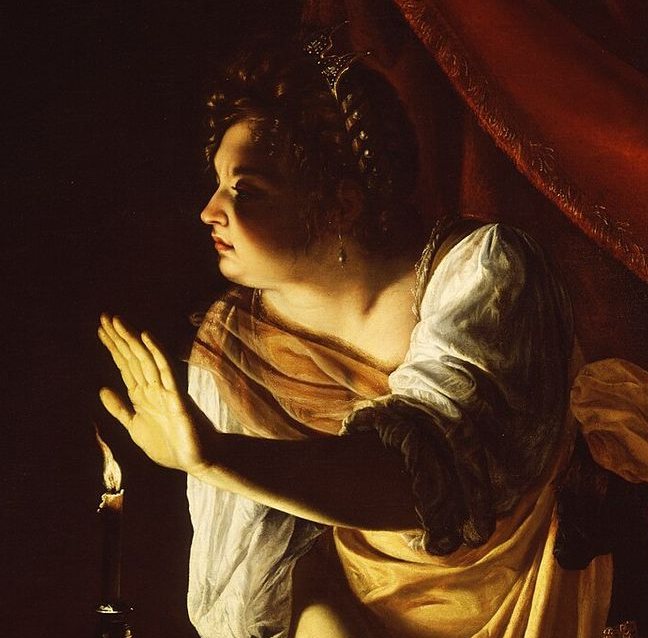 Detail of a woman in yellow raising one hand toward a candle, shading its light; her face and hand are lit against near-black darkness, her forearm in shadow.